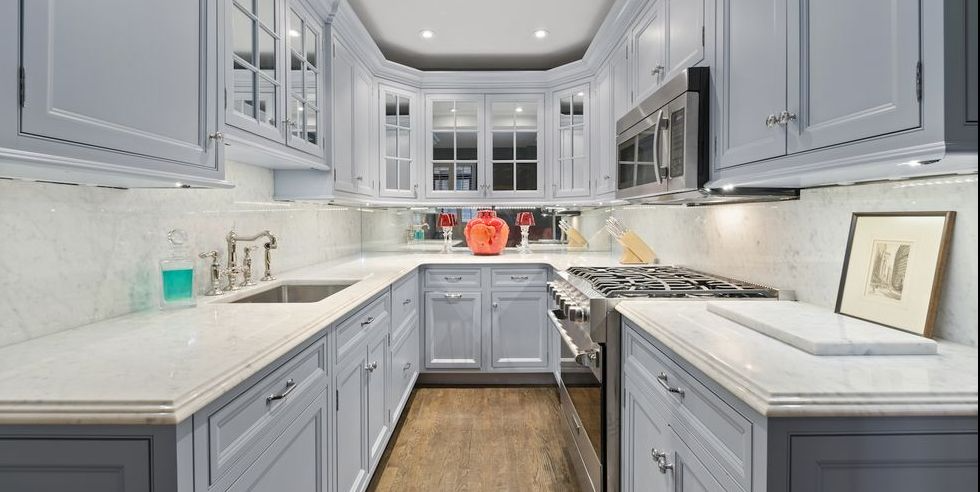 Stylish Small Kitchens, mirrored backsplash and light colored cabinets give the elusion of a bigger space