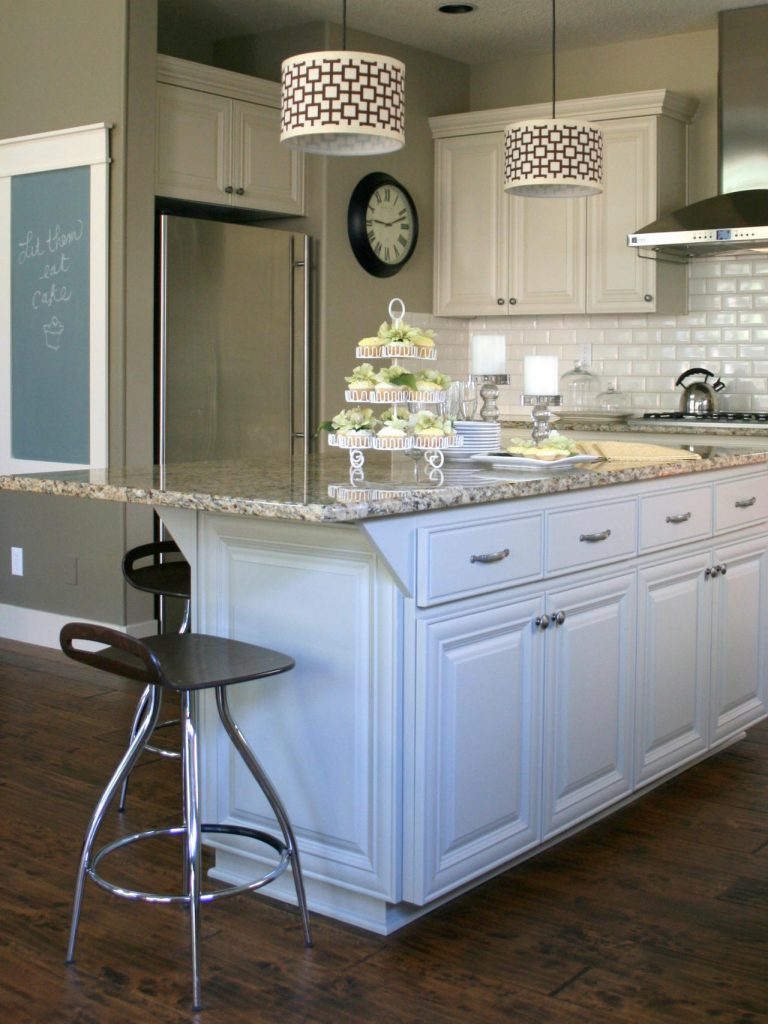 white kitchen cabinets with marble countertop with overhang