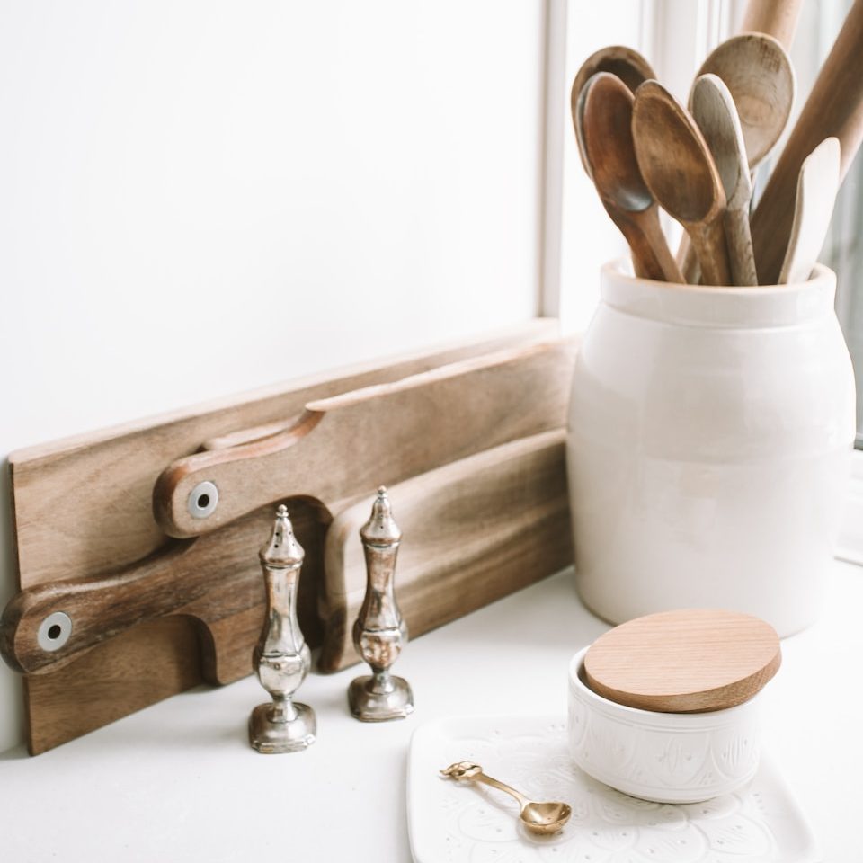 brown wooden spoons on ceramic canister on white top surface