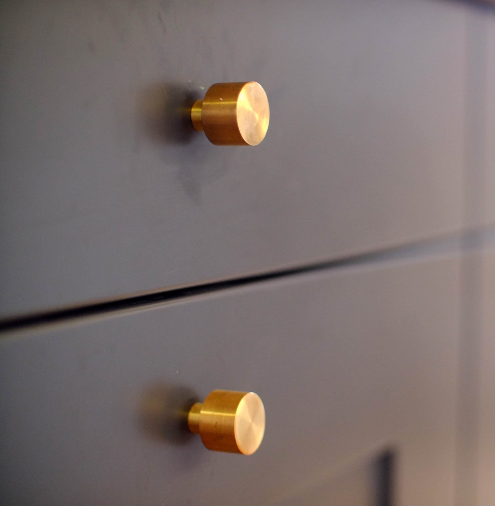 dark drawer fronts with gold knobs
