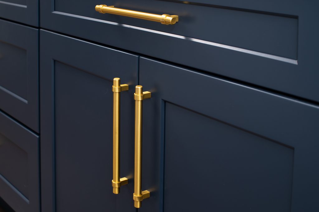 close up of painted cabinet doors with a slight sheen to the paint finish and shiny brass handles.
