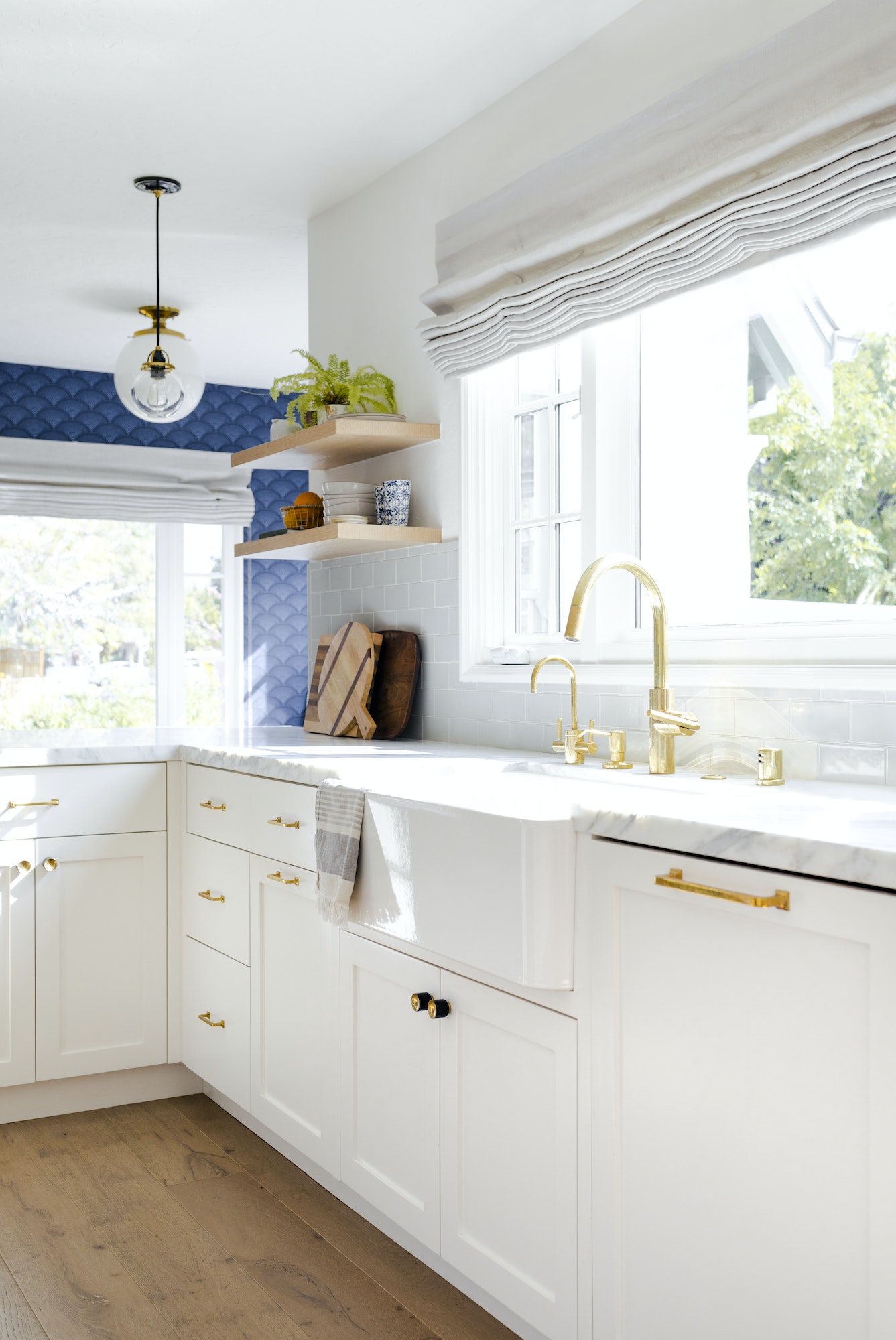 shaker style cabinet doors in a bright and white kitchen with a gold faucet
