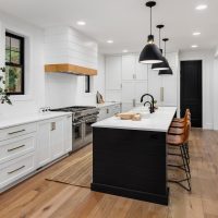 Beautiful white kitchen with dark accents in new modern farmhouse style luxury home