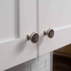 silver knobs on white cabinet doors
