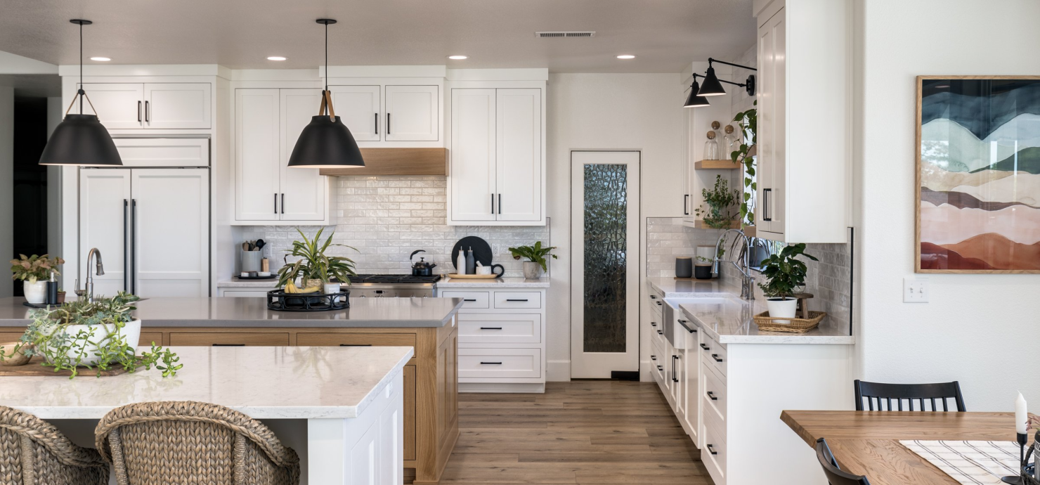 farmhouse style kitchen with white cabinets, lighting, and island