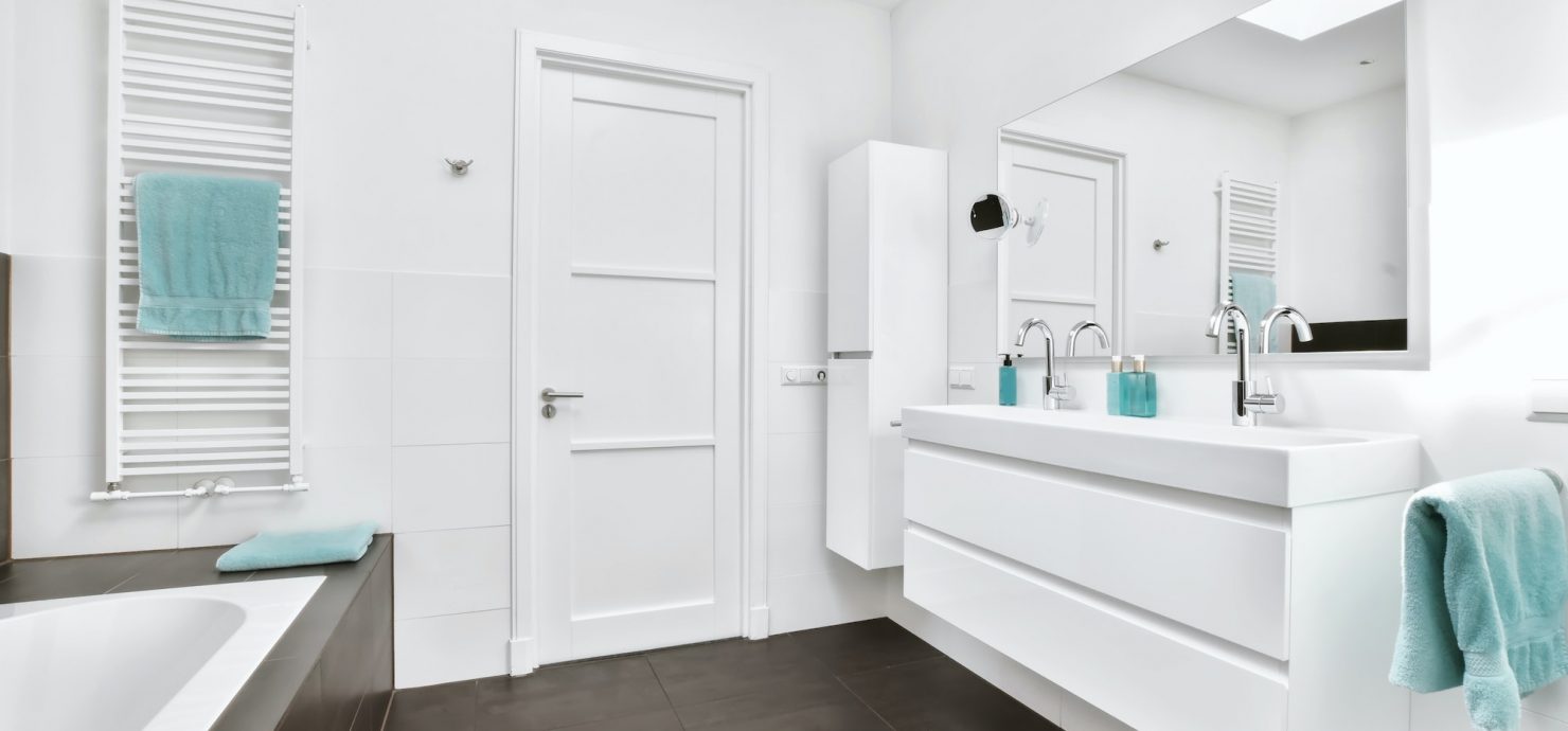 The bathroom is in a minimalist style with a white chest of drawers