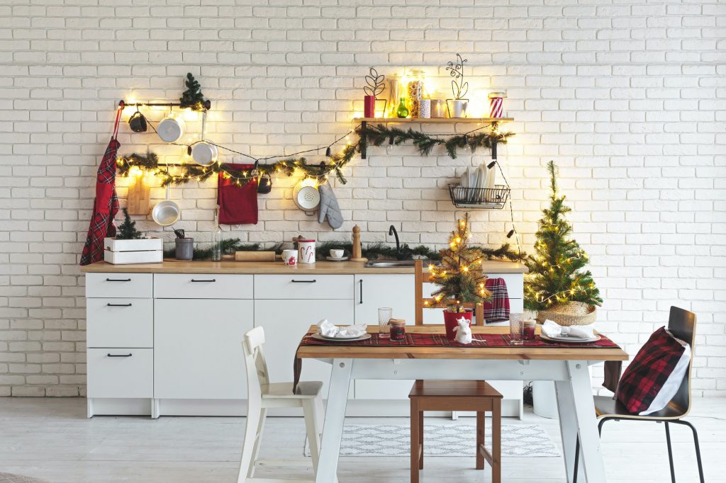 Interior white kitchen with lights and red christmas decorations