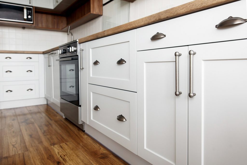 customize cabinet hardware by matching the style to your cabinets. These silver pulls and handles on white cabinets are a great example.