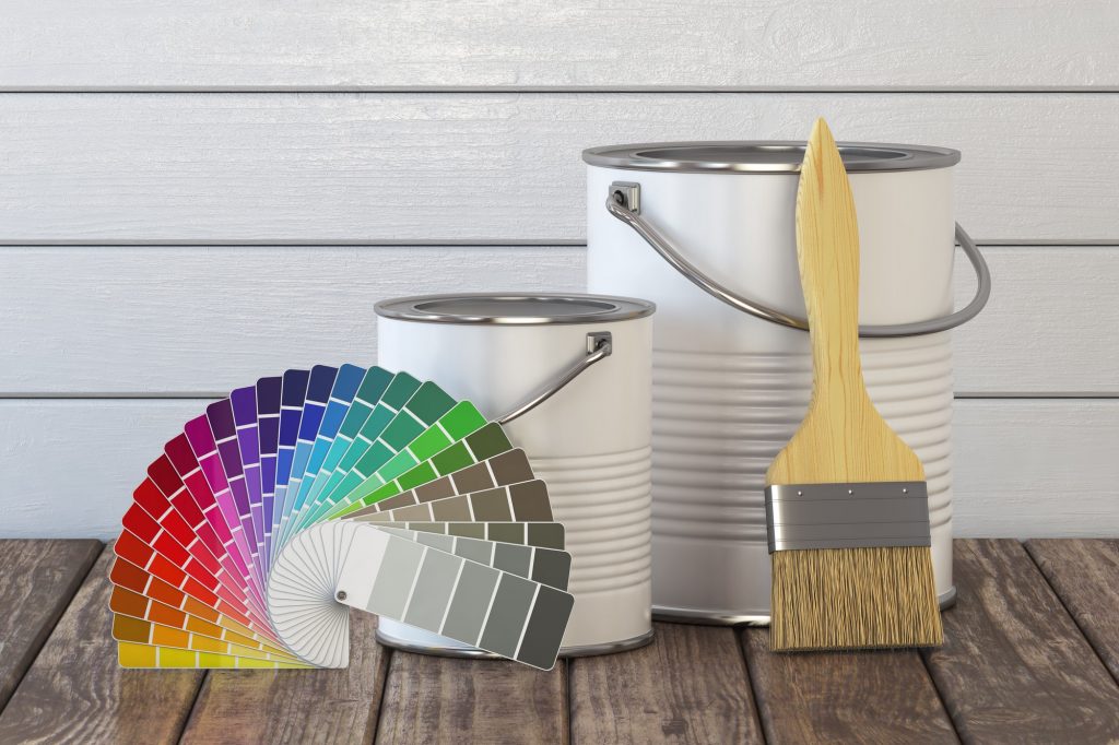 Paint cans, paint brush and color palette on wood table.